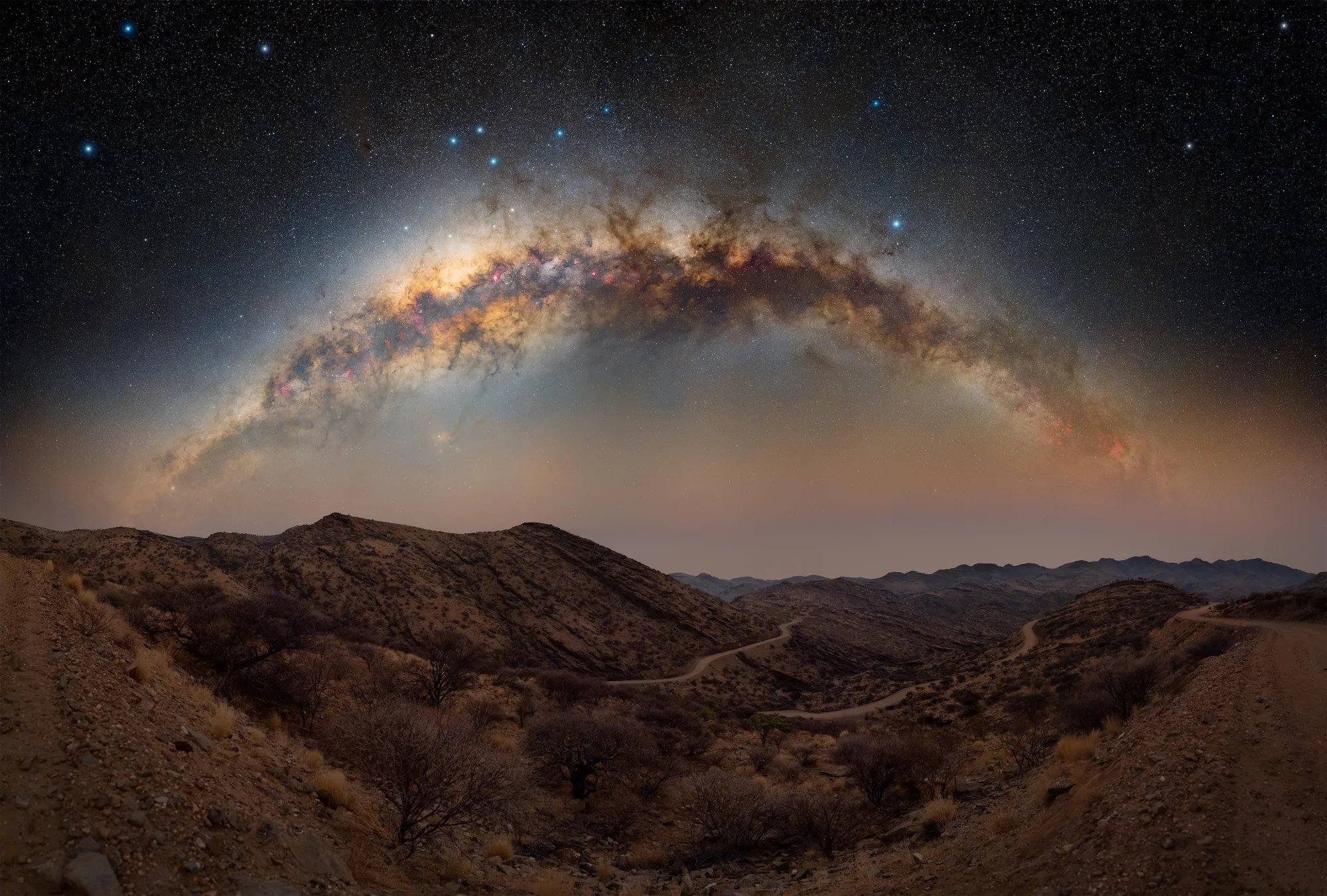 The Milky Way over a dark mountain ridge in the Namibian night sky.