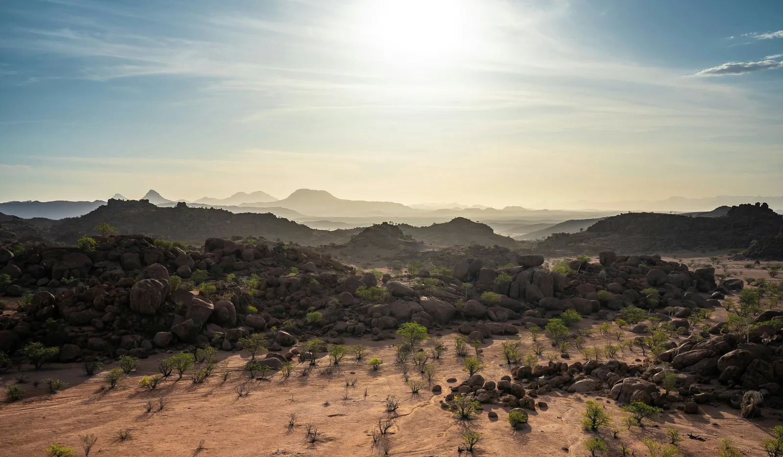 Granite boulders and far blue ridges under a hazy afternoon sun