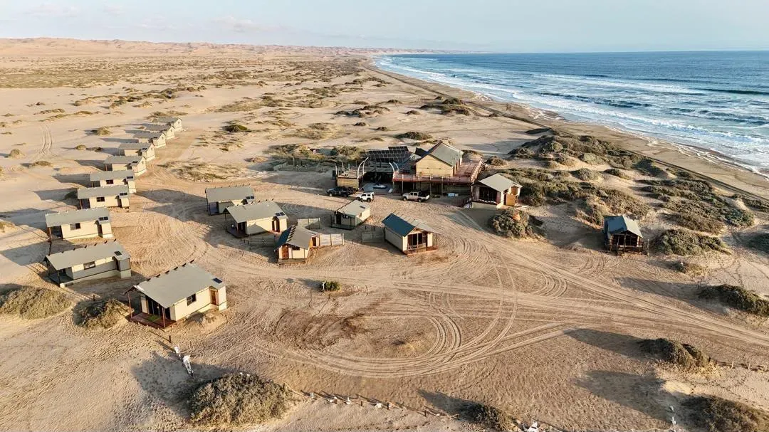 Meob Lodge scattered along the dunes above the Atlantic shore