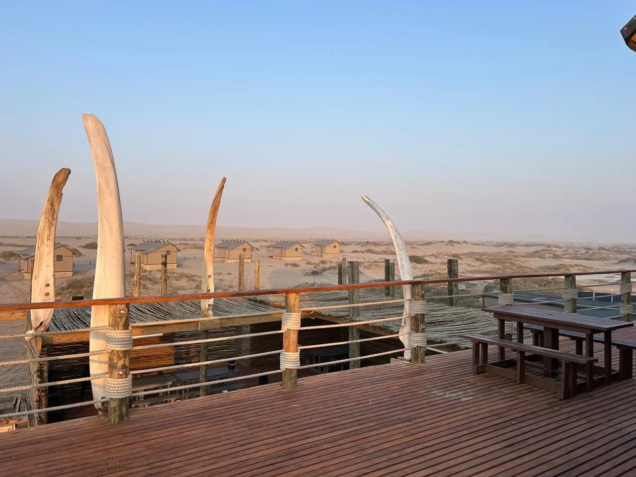 Whalebone arches frame the cabins of Meob Lodge at dusk