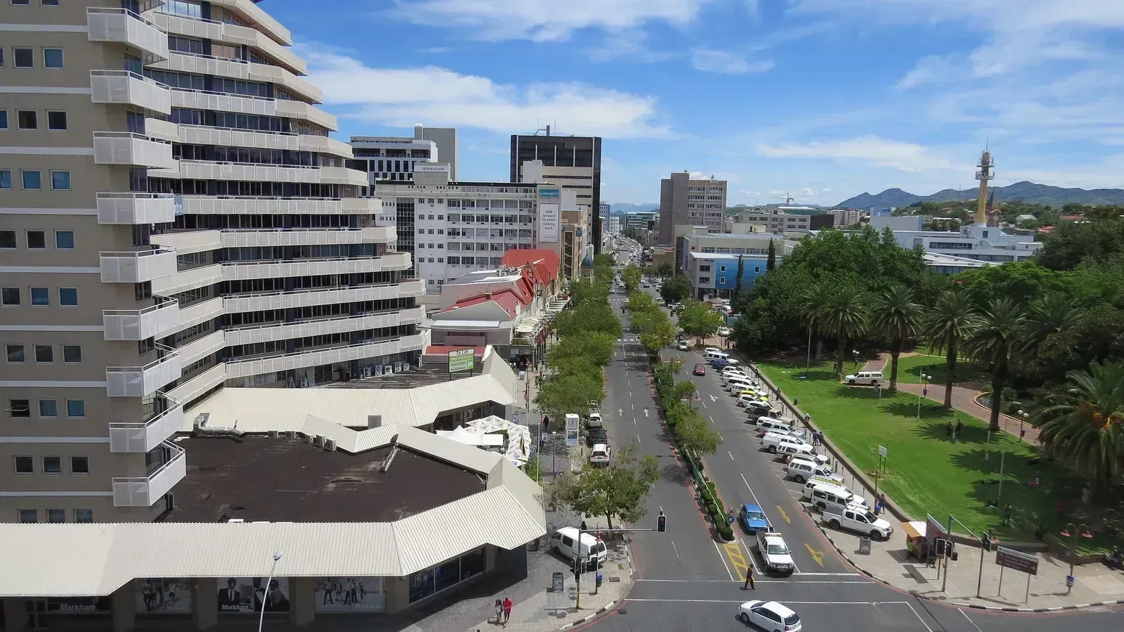 A quiet, tree-lined avenue through the business district under a soft highland sky